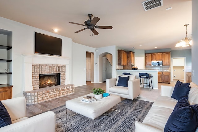 1908 Canyon Wren Dr, Mckinney, TX 75071 - living room featuring a ceiling fan, a fireplace, recessed lighting, and arched walkways