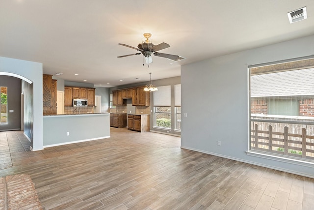 1908 Canyon Wren Dr, Mckinney, TX 75071 - unfurnished living room with healthy amount of natural light, light wood finished floors, ceiling fan, baseboards, and recessed lighting
