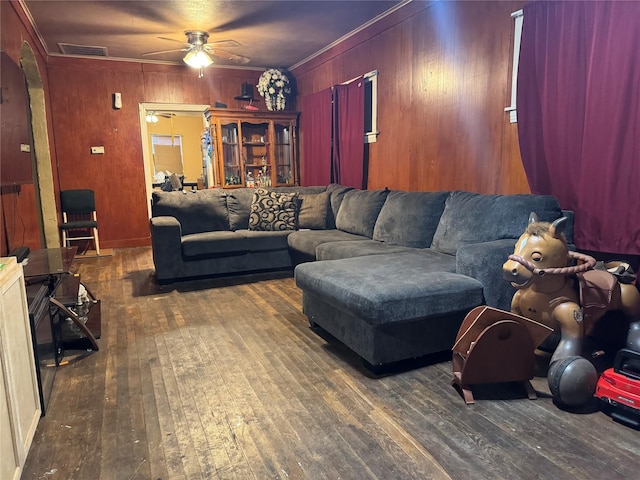 1206 Walnut St, Greenville, TX 75401 - living area featuring hardwood / wood-style flooring, arched walkways, wood walls, a ceiling fan, and ornamental molding