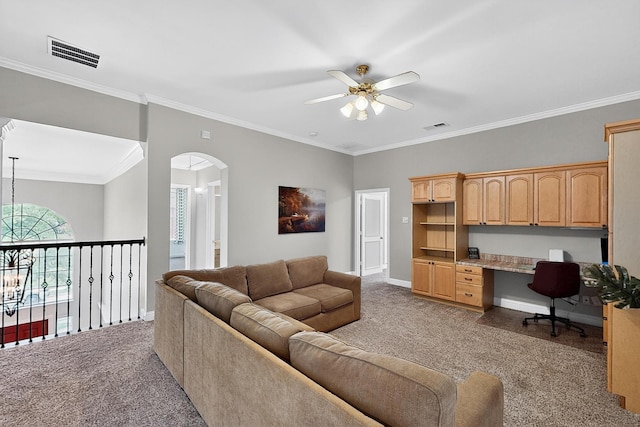 4700 Scoter Ln, Mckinney, TX 75072 - living area with light colored carpet, a ceiling fan, built in desk, arched walkways, and crown molding