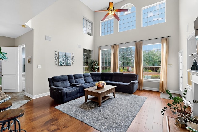 4700 Scoter Ln, Mckinney, TX 75072 - living room featuring a towering ceiling, a ceiling fan, healthy amount of natural light, and light wood-style flooring