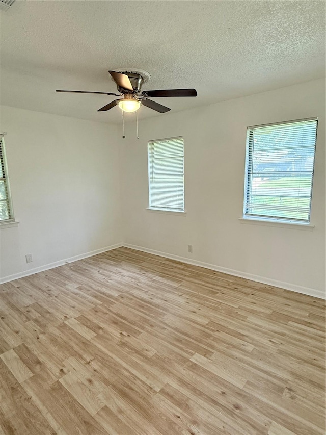 1136 Simpson Dr, Hurst, TX 76053 - empty room featuring a textured ceiling, light wood-style floors, and ceiling fan