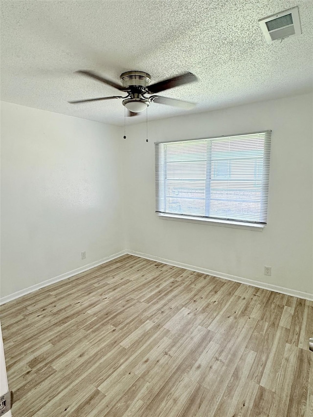 1136 Simpson Dr, Hurst, TX 76053 - spare room featuring a textured ceiling, light wood finished floors, and a ceiling fan