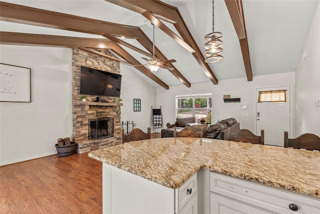 102 Anderson Ln, Mabank, TX 75156 - kitchen with ceiling fan, light stone countertops, open floor plan, white cabinets, and a stone fireplace