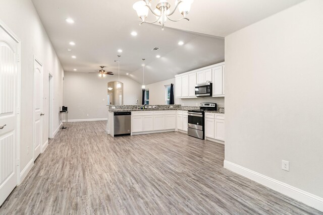 3760 Soft Wind Dr, Dallas, TX 75241 - kitchen featuring appliances with stainless steel finishes, open floor plan, a peninsula, light wood-style floors, and lofted ceiling