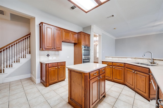 2673 April Sound Ln, Frisco, TX 75033 - kitchen featuring a sink, brown cabinetry, light countertops, and ornamental molding