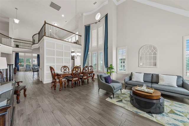 3300 Calvin Rd, Mckinney, TX 75071 - living room featuring high vaulted ceiling, wood finished floors, a chandelier, ornamental molding, and baseboards