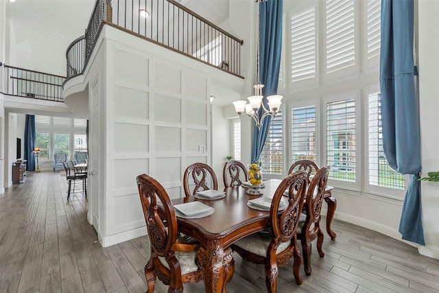 3300 Calvin Rd, Mckinney, TX 75071 - dining space featuring a high ceiling, wood finished floors, a chandelier, baseboards, and stairway