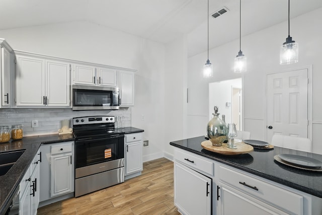 3220 Steamboat Dr, Fort Worth, TX 76123 - kitchen featuring appliances with stainless steel finishes, backsplash, pendant lighting, lofted ceiling, and light wood-style flooring