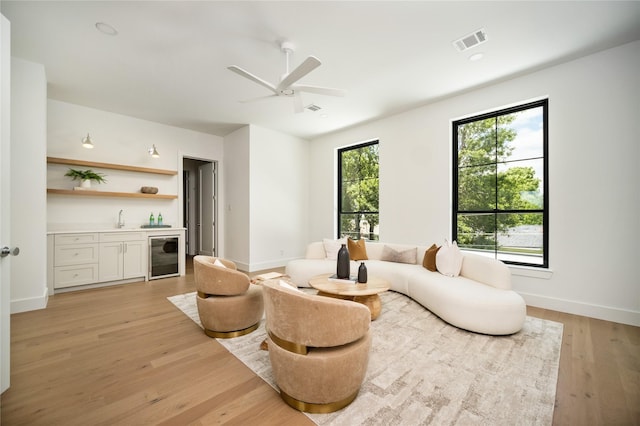 3727 Clover Ln, Dallas, TX 75220 - living room featuring wine cooler, wet bar, ceiling fan, and light wood-style floors
