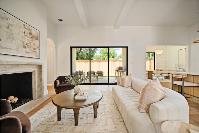 3727 Clover Ln, Dallas, TX 75220 - living room featuring beamed ceiling, wood finished floors, a fireplace, and arched walkways