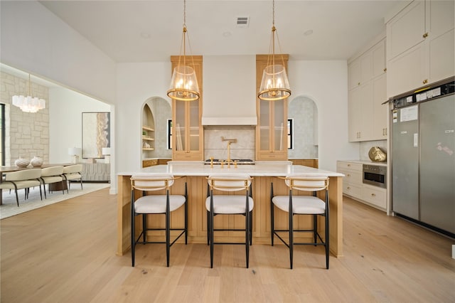3727 Clover Ln, Dallas, TX 75220 - kitchen with stainless steel fridge, a chandelier, tasteful backsplash, light countertops, and light wood-style flooring
