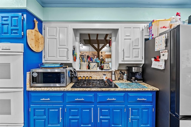 907 Green Terrace Ln, Duncanville, TX 75137 - kitchen featuring stainless steel appliances, blue cabinetry, white cabinets, and light countertops