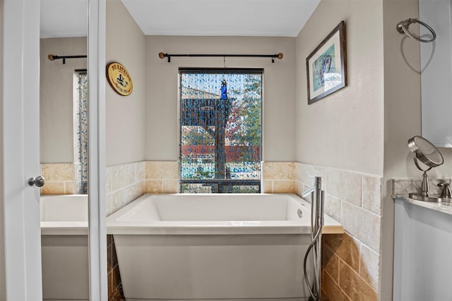 907 Green Terrace Ln, Duncanville, TX 75137 - bathroom with tile walls, a tub to relax in, and a wainscoted wall