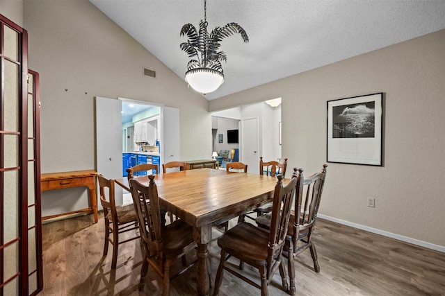 907 Green Terrace Ln, Duncanville, TX 75137 - dining room featuring wood finished floors, high vaulted ceiling, and a chandelier
