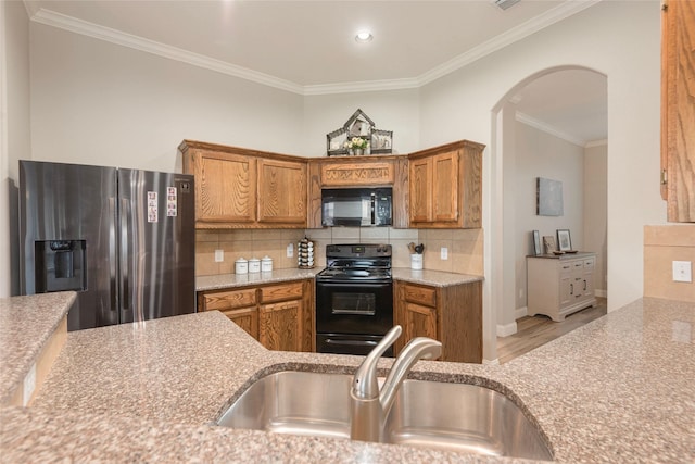 102 Avery Ln, Fate, TX 75189 - kitchen with black appliances, a sink, crown molding, brown cabinetry, and wood finished floors
