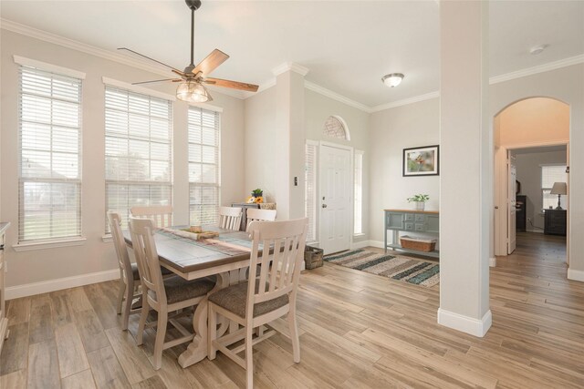 102 Avery Ln, Fate, TX 75189 - dining area with arched walkways, a ceiling fan, light wood finished floors, crown molding, and baseboards