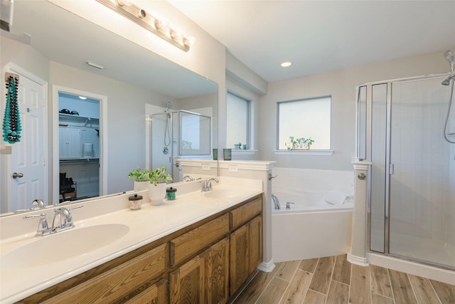 102 Avery Ln, Fate, TX 75189 - bathroom with a shower stall, a walk in closet, a garden tub, double vanity, and wood finished floors