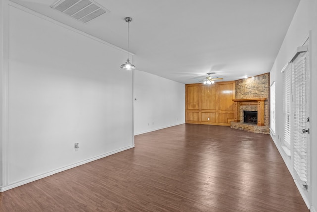 6814 Silver Lake Dr, Rowlett, TX 75089 - unfurnished living room featuring a ceiling fan, dark wood finished floors, a brick fireplace, and baseboards