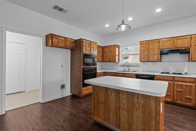 6814 Silver Lake Dr, Rowlett, TX 75089 - kitchen with black appliances, a sink, brown cabinets, light countertops, and recessed lighting