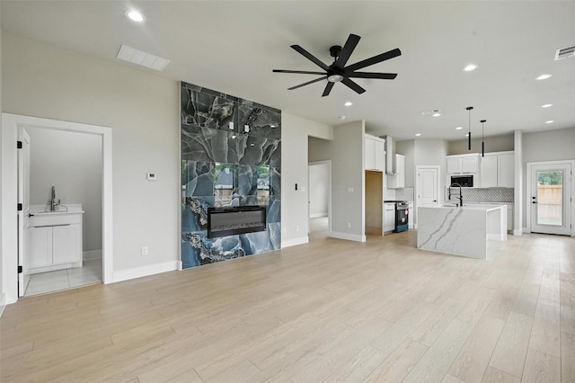 1901 Varsity Dr, Grand Prairie, TX 75051 - unfurnished living room featuring ceiling fan, light wood-style floors, recessed lighting, baseboards, and a sink
