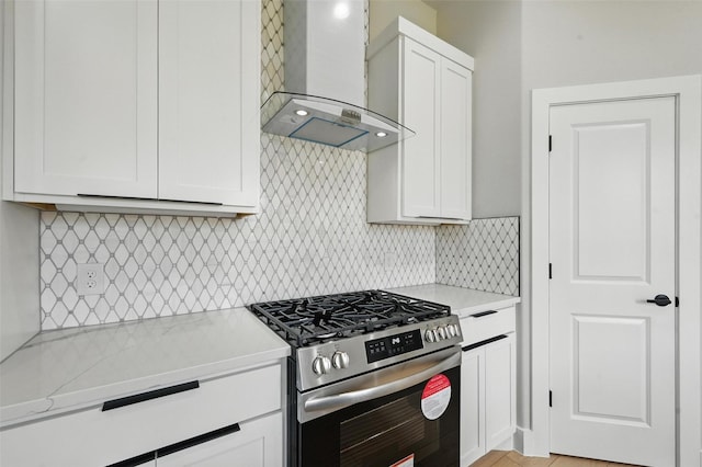 1901 Varsity Dr, Grand Prairie, TX 75051 - kitchen with stainless steel gas stove, wall chimney range hood, white cabinets, and decorative backsplash