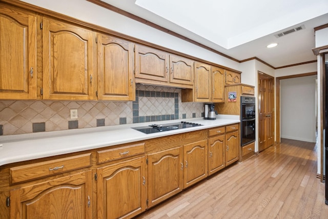 1533 Aylesbury Ln, Plano, TX 75075 - kitchen with black appliances, tasteful backsplash, light wood-style floors, brown cabinets, and light countertops