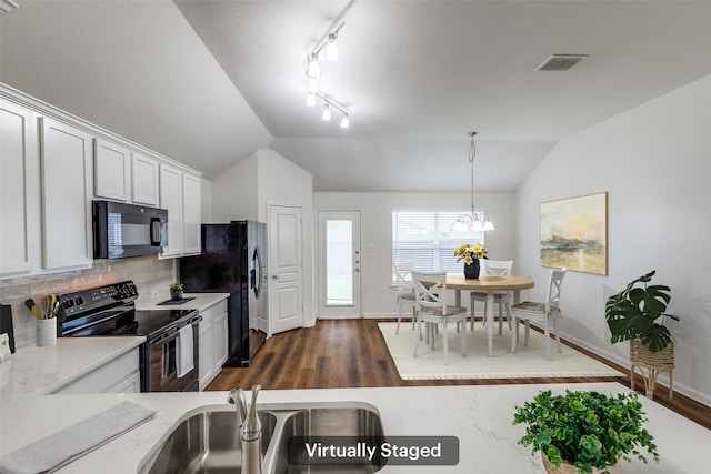 2704 Calmwater Dr, Little Elm, TX 75068 - kitchen featuring black appliances, vaulted ceiling, dark wood finished floors, tasteful backsplash, and hanging light fixtures
