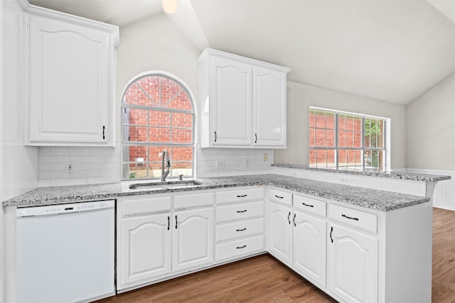 7816 Blossom Dr, Fort Worth, TX 76133 - kitchen featuring dishwasher, a sink, a peninsula, lofted ceiling, and light stone counters