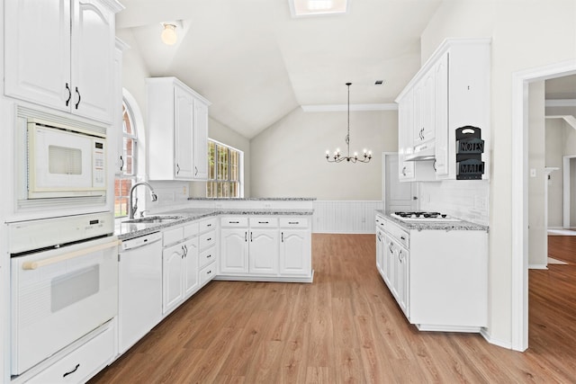 7816 Blossom Dr, Fort Worth, TX 76133 - kitchen featuring white appliances, a peninsula, white cabinetry, light wood finished floors, and vaulted ceiling