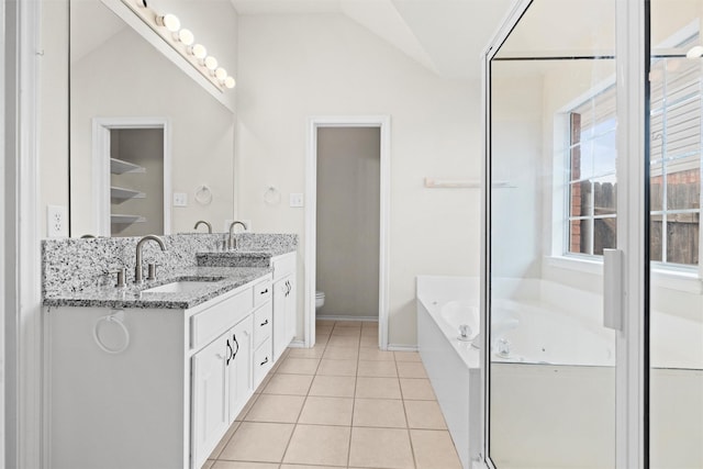 7816 Blossom Dr, Fort Worth, TX 76133 - full bath with double vanity, a bath, toilet, vaulted ceiling, and tile patterned flooring