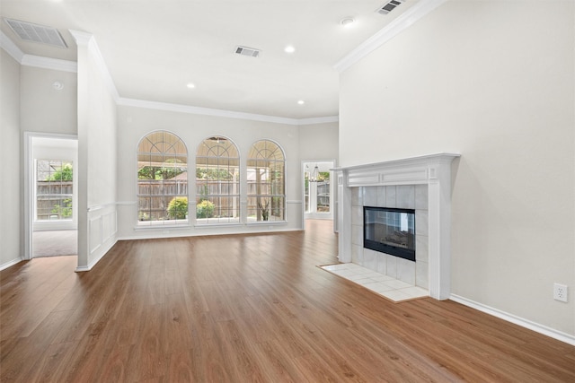 7816 Blossom Dr, Fort Worth, TX 76133 - unfurnished living room featuring wood finished floors, ornamental molding, a tiled fireplace, baseboards, and recessed lighting