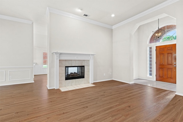 7816 Blossom Dr, Fort Worth, TX 76133 - unfurnished living room featuring wood finished floors, a chandelier, crown molding, a tile fireplace, and a high ceiling