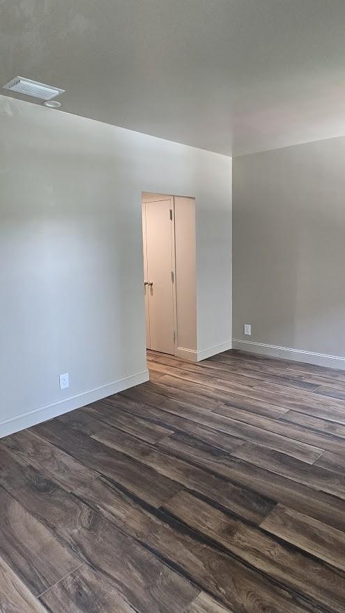 6211 W NW Hwy Unit G224, Dallas, TX 75225 - empty room featuring dark wood-type flooring and baseboards