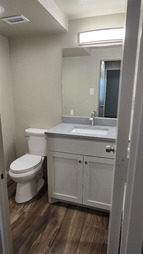 6211 W NW Hwy Unit G224, Dallas, TX 75225 - half bath with vanity, toilet, and wood finished floors