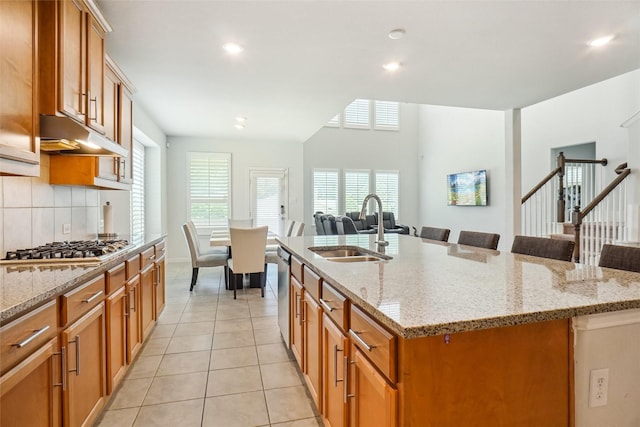 2612 Dancing Flame Dr, Denton, TX 76201 - kitchen featuring a sink, open floor plan, light tile patterned floors, a kitchen island with sink, and appliances with stainless steel finishes