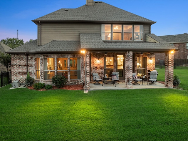 6619 Crestmoor Ln, Sachse, TX 75048 - back of house at dusk featuring brick siding, a patio area, and roof with shingles