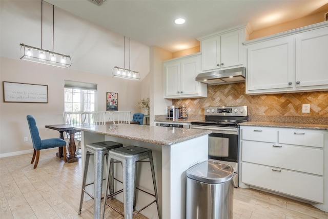 112 Tigers Eye Ct, Weatherford, TX 76087 - kitchen featuring under cabinet range hood, electric range, a kitchen bar, a kitchen island, and light wood finished floors