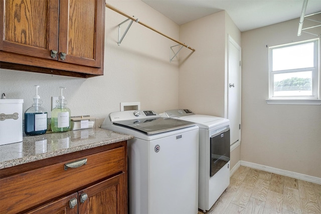 112 Tigers Eye Ct, Weatherford, TX 76087 - laundry area with light wood-type flooring, cabinet space, washing machine and clothes dryer, and baseboards