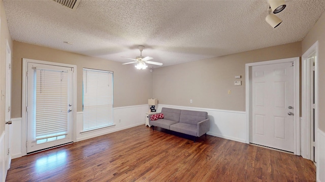 1931 Crestside Cir, Carrollton, TX 75007 - living area featuring wood finished floors, ceiling fan, a textured ceiling, and a wainscoted wall