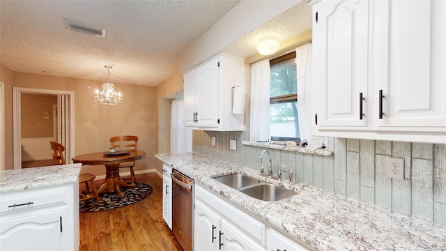 1931 Crestside Cir, Carrollton, TX 75007 - kitchen featuring a sink, stainless steel dishwasher, wood finished floors, white cabinetry, and a textured ceiling