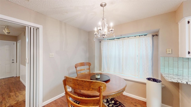 1931 Crestside Cir, Carrollton, TX 75007 - dining space featuring a chandelier, a textured ceiling, wood finished floors, and baseboards