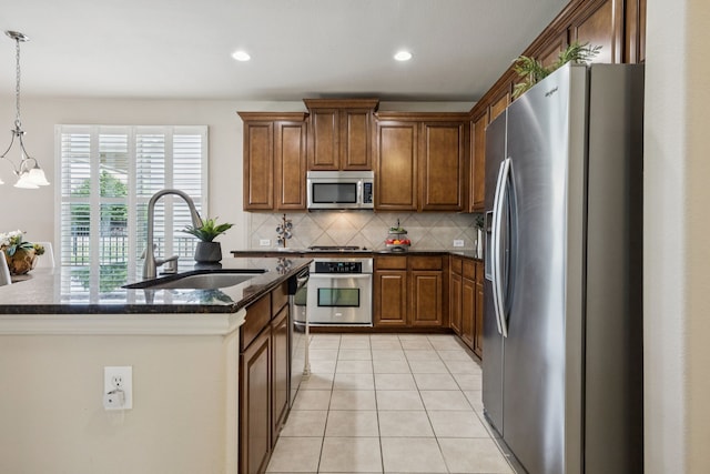 8100 Delaware Dr, Mckinney, TX 75070 - kitchen featuring stainless steel appliances, a sink, tasteful backsplash, dark stone counters, and a kitchen island with sink