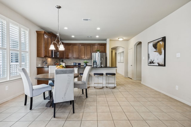 8100 Delaware Dr, Mckinney, TX 75070 - dining space with arched walkways, healthy amount of natural light, light tile patterned floors, recessed lighting, and baseboards