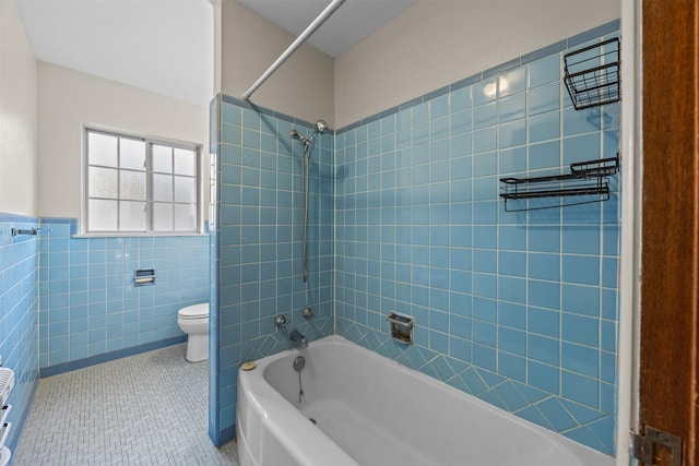 3212 Medina Ave, Fort Worth, TX 76133 - bathroom with tile patterned flooring, tile walls, toilet, shower / bath combination, and a wainscoted wall