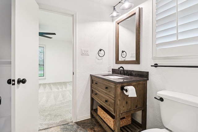 1510 Waltham Ct, Arlington, TX 76012 - bathroom featuring vanity, toilet, a textured wall, and stone finish floors