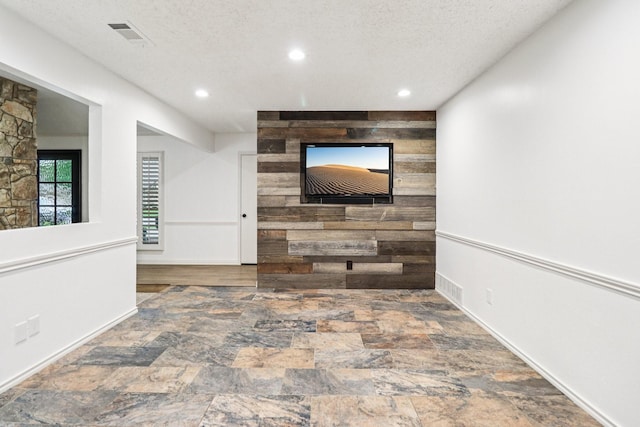 1510 Waltham Ct, Arlington, TX 76012 - hallway with stone finish floors, recessed lighting, wood walls, a textured ceiling, and baseboards