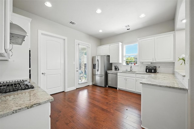 7514 Harbor Dr, Rowlett, TX 75088 - kitchen featuring appliances with stainless steel finishes, extractor fan, white cabinetry, tasteful backsplash, and recessed lighting