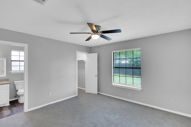36 Atlantic Ave, Midlothian, TX 76065 - unfurnished bedroom featuring a walk in closet, ensuite bathroom, dark colored carpet, and baseboards