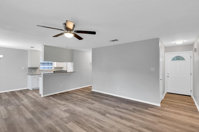 36 Atlantic Ave, Midlothian, TX 76065 - unfurnished living room with light wood finished floors, ceiling fan, and baseboards